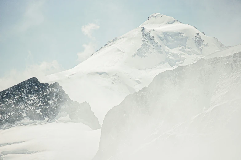 a snowboarder rides down a mountain side in the distance