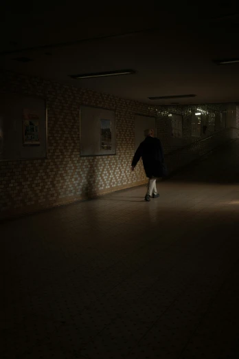 there is a man in a dark hallway with his back to the camera