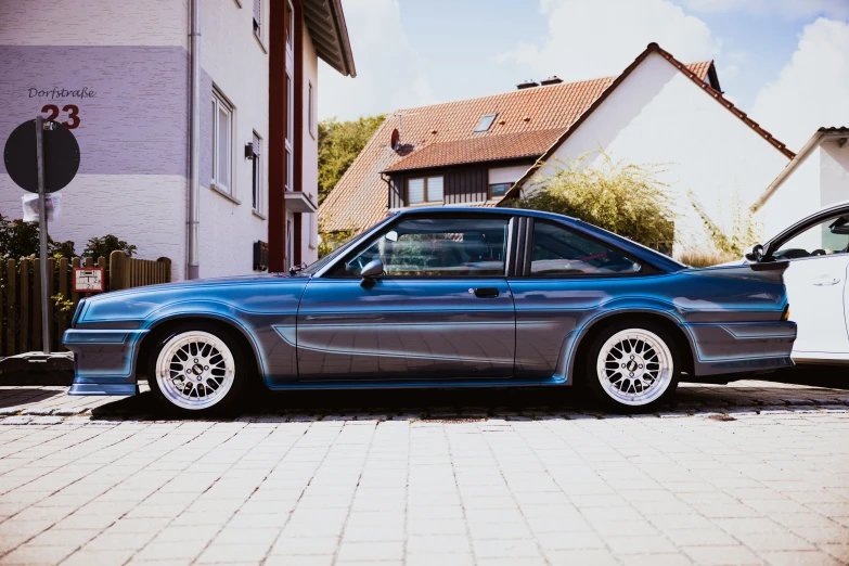 a very nice looking blue car sitting in the parking lot