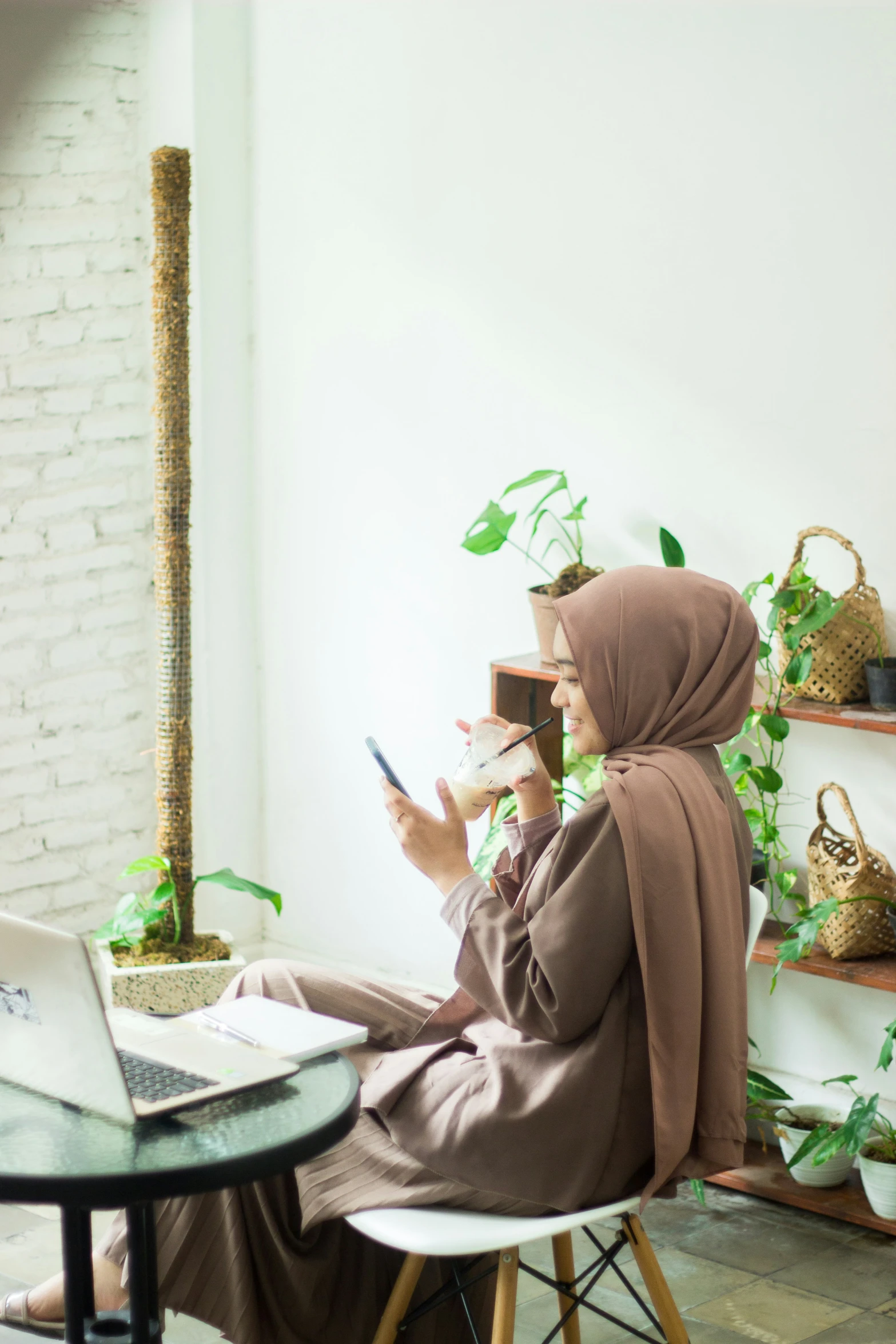 the woman is sitting at the table looking at her cellphone