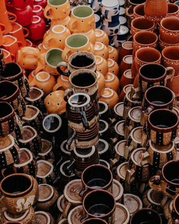 there is many orange and brown jars that are stacked together