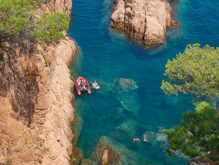 three people in boats are floating on the blue water