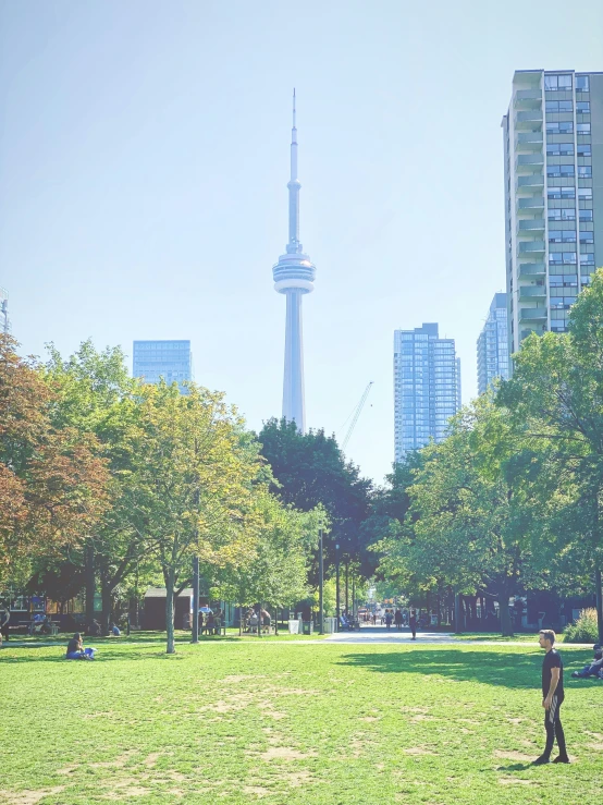 a child plays in a large park with the skyline in the background