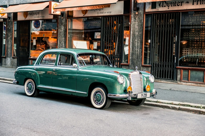 the old green classic car has a striped decoration on the door