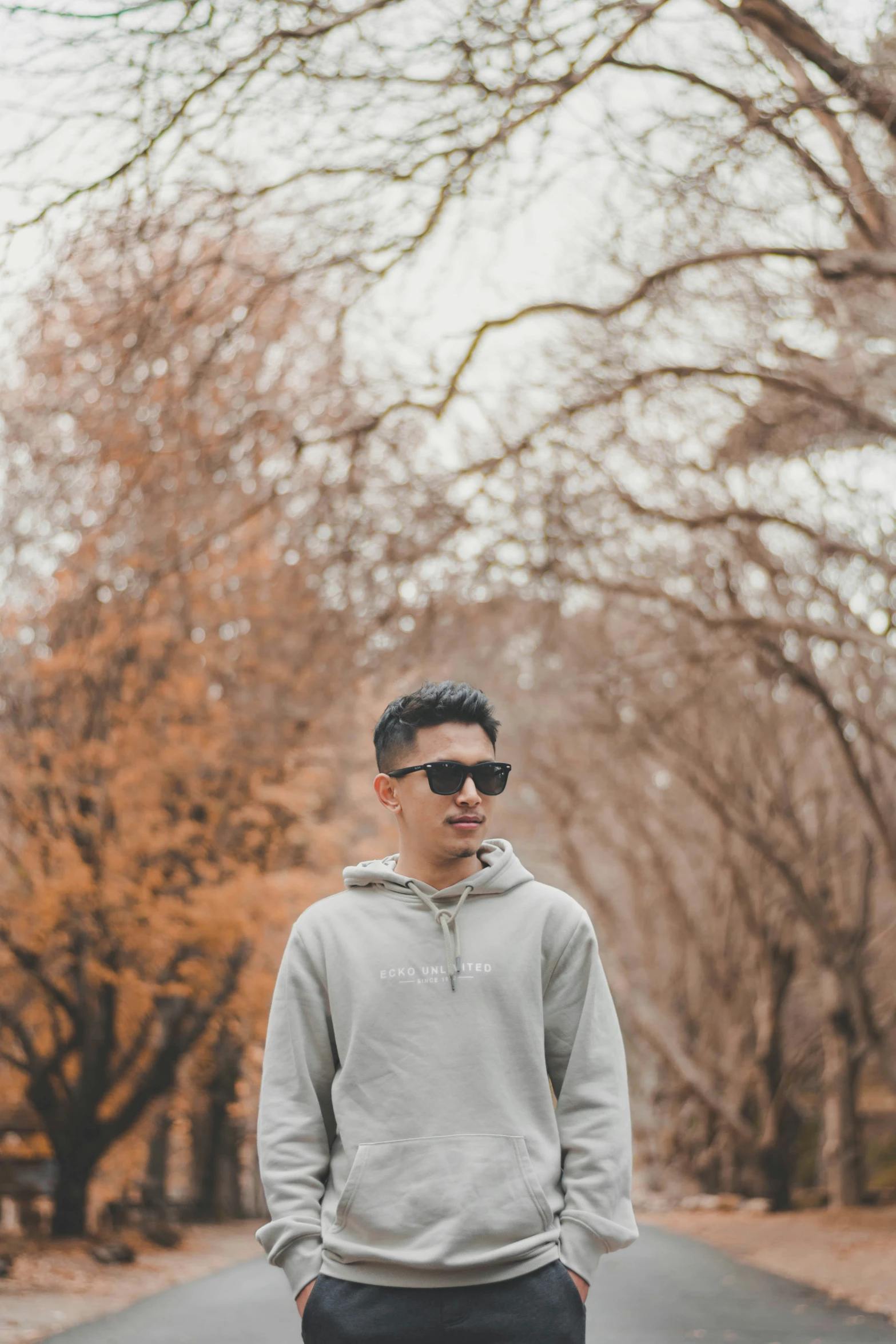 a man is wearing sunglasses and standing next to the street