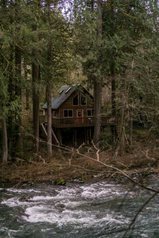 a house in the woods next to the water