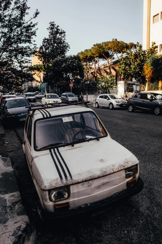 an abandoned car in a parking lot with it's hood down