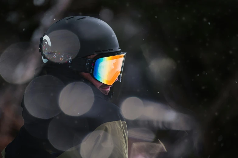 man wearing a protective helmet and glasses, looking off into the distance