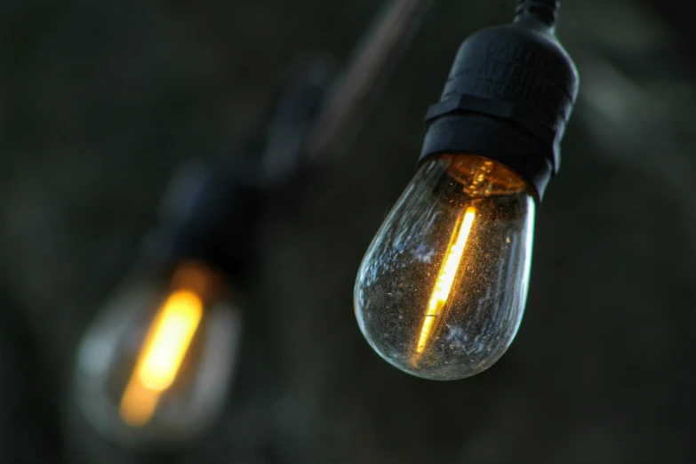 two lights that are lit up on some wires