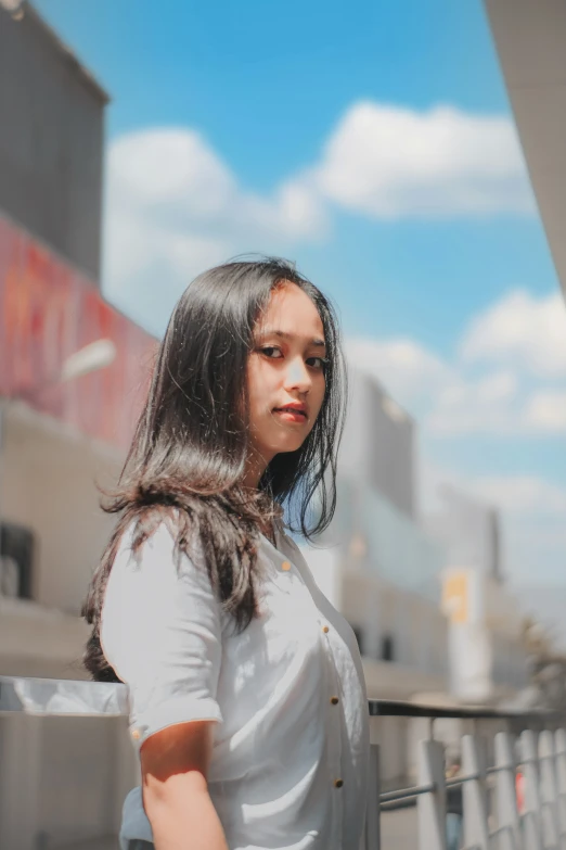 a young woman in a white shirt is standing in a city