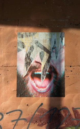 an abstract graffiti pograph on a wall showing an open mouth and teeth