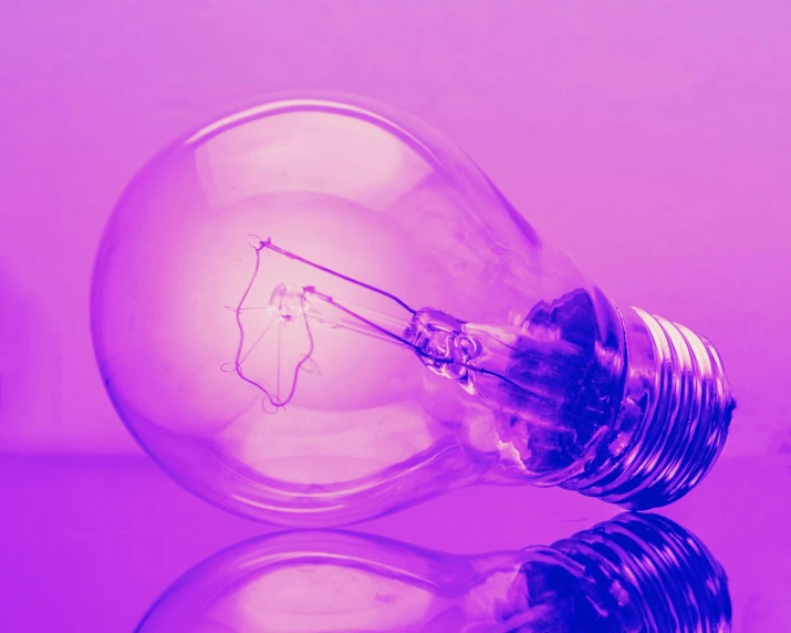 a light bulb is sitting on a purple background