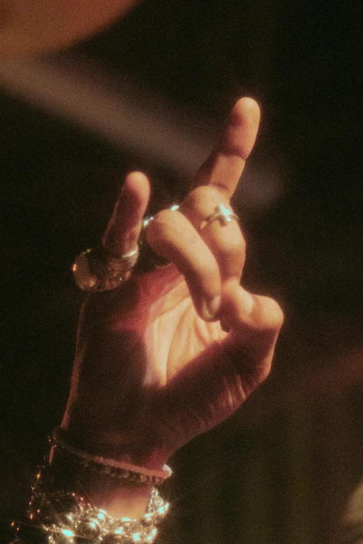 a woman is making a sign with her hands