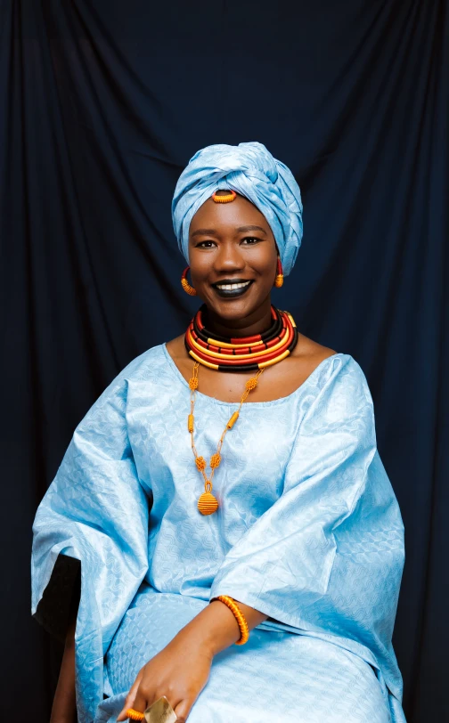 the woman is wearing a blue dress with beads