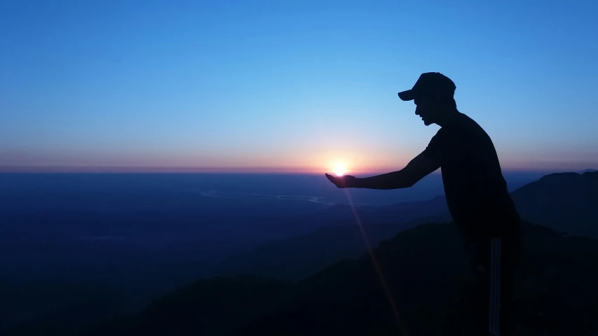 the man is taking a po of a sunset on top of a mountain
