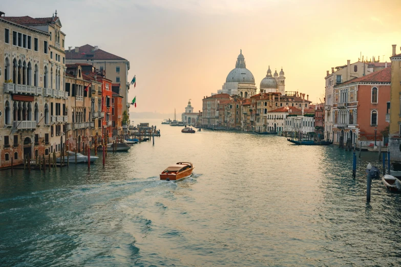 the boats are driving down the water by buildings