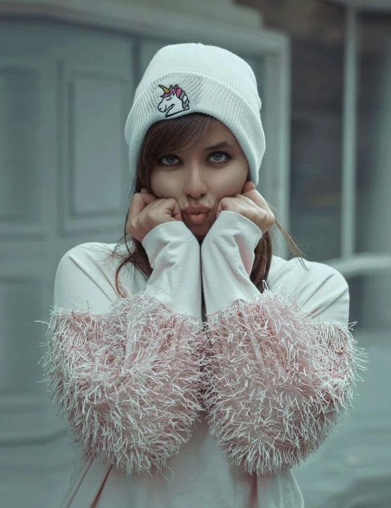 a girl in white with fluffy sleeves covering her face and hand on the wrist