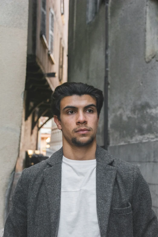 a man standing in the street wearing a gray jacket