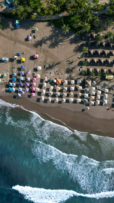 an overhead s of the beach with a line of colorful beach umbrellas