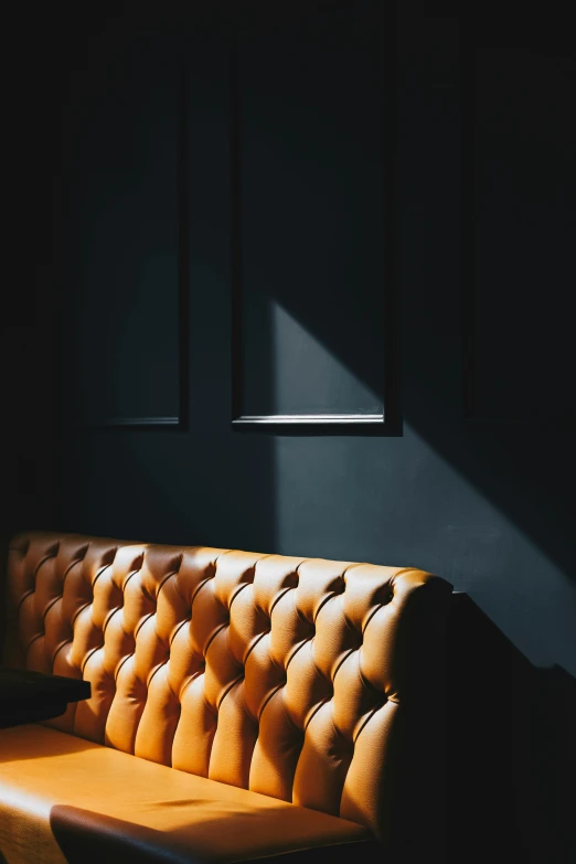 an orange leather sofa facing a window