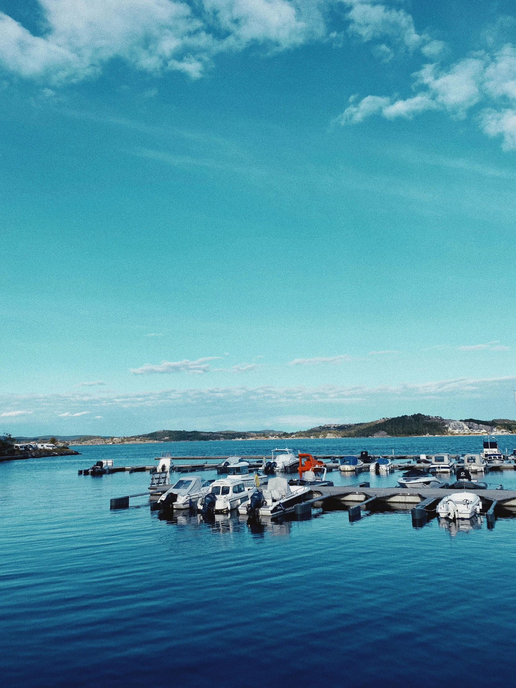 there are many boats in the lake and a lighthouse in the background