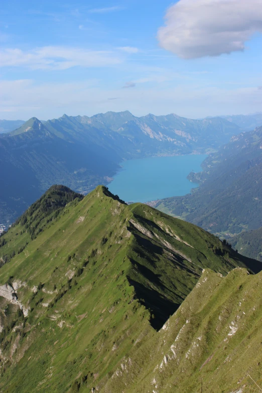 a grassy mountain with water in the distance