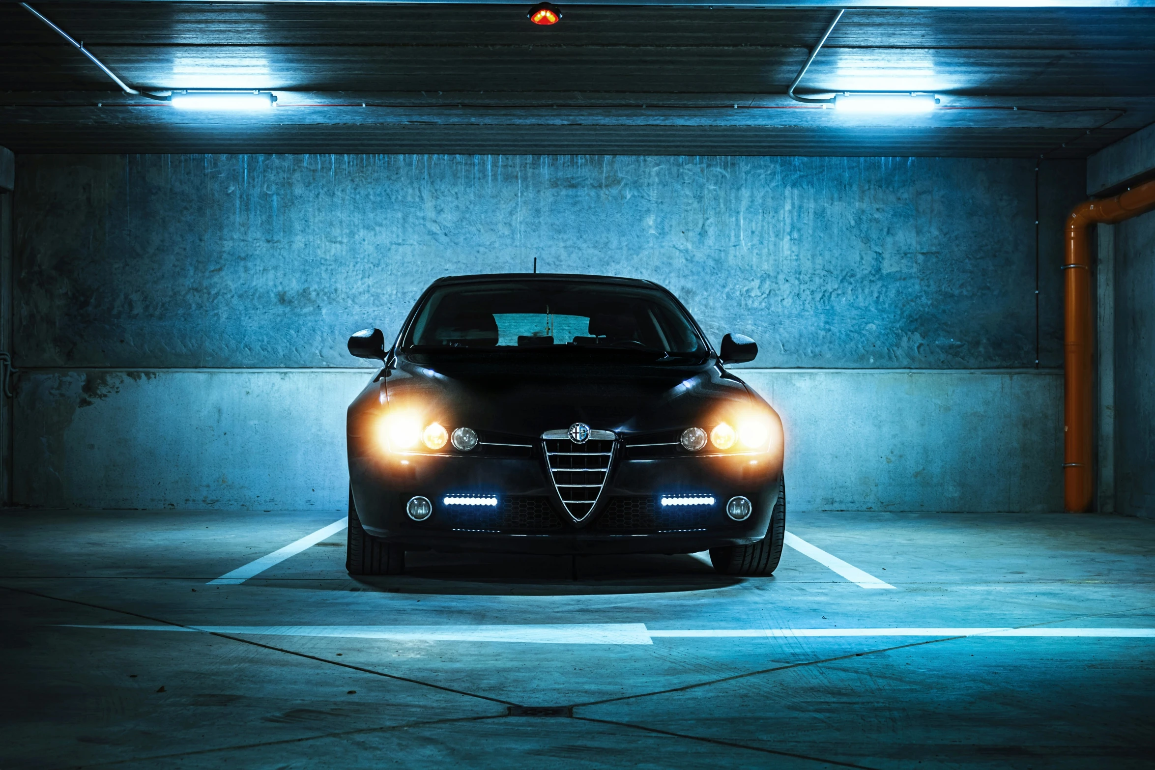 car with its headlights on in a parking garage