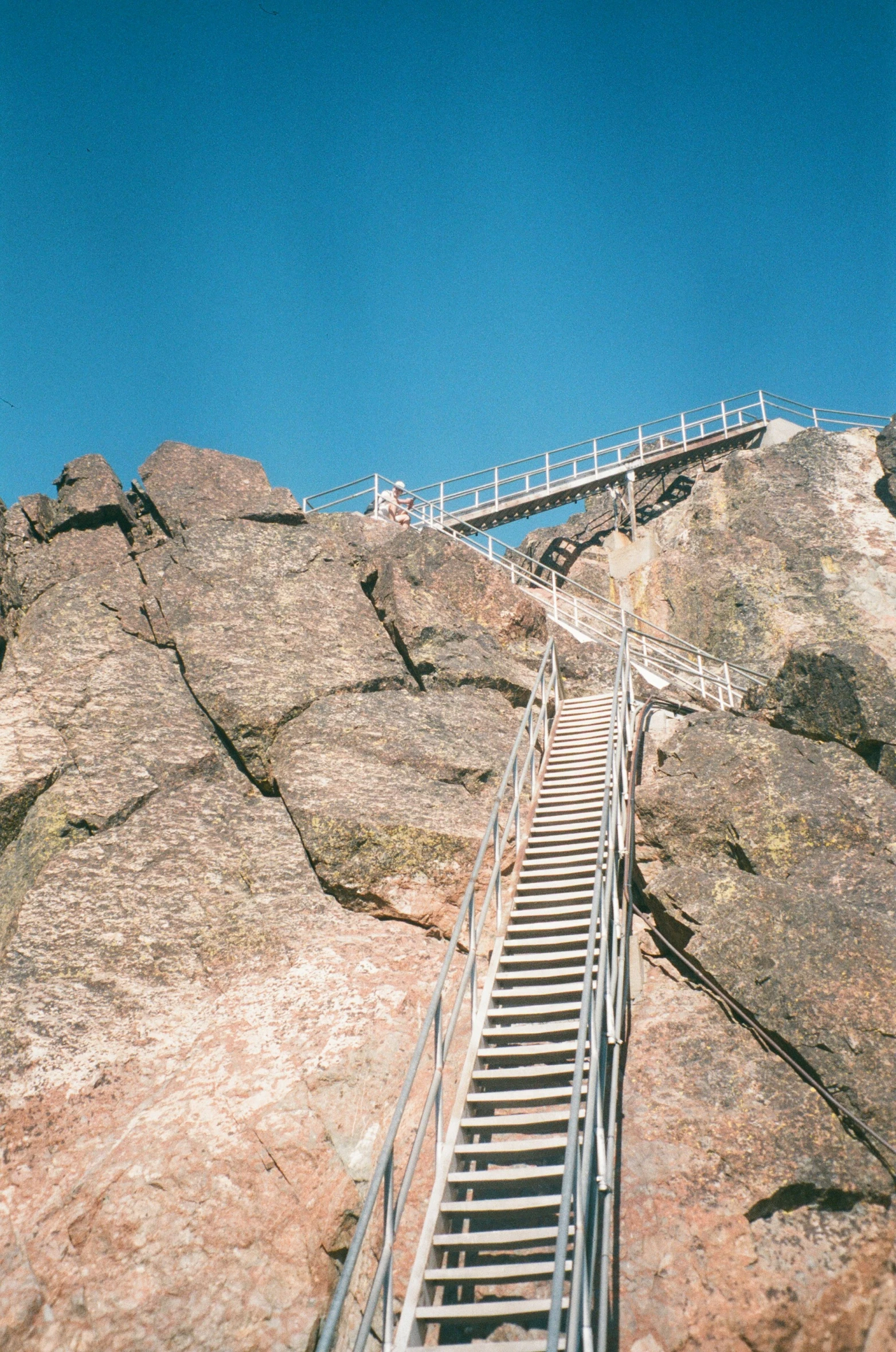 a group of people walking along a ladder in the middle of some mountains