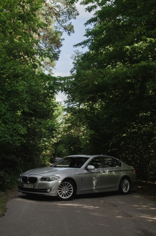 a silver bmw parked on the side of the road