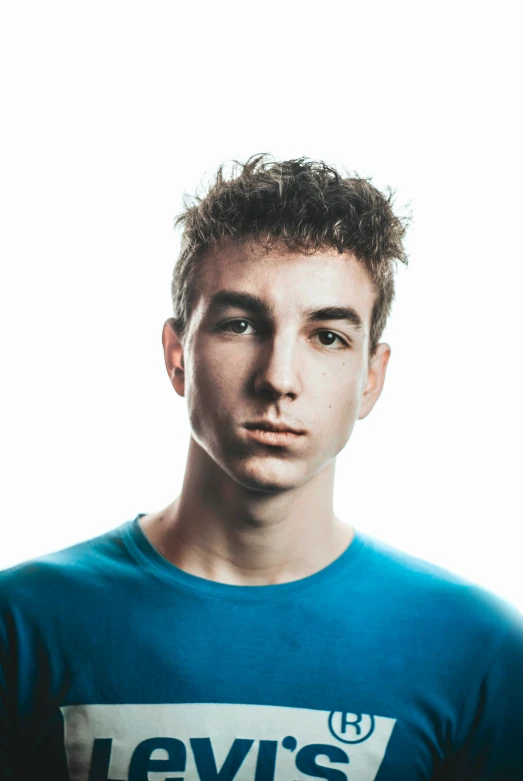 a young man in blue shirt posing for camera