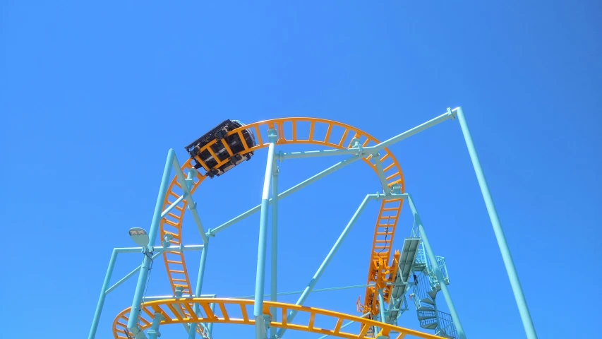 a roller coaster rides under a blue sky