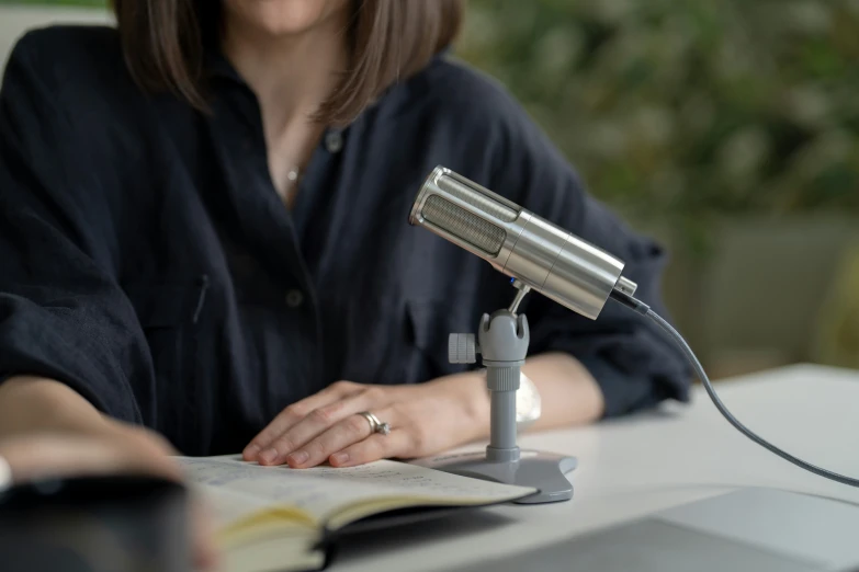 a woman holding a book in front of a microphone