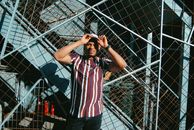 a man is standing against a pile of metal bars