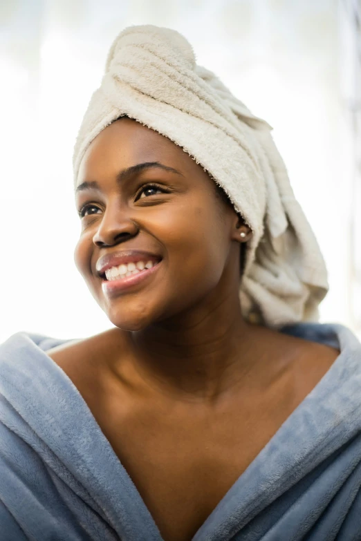 a woman with a towel on her head smiles