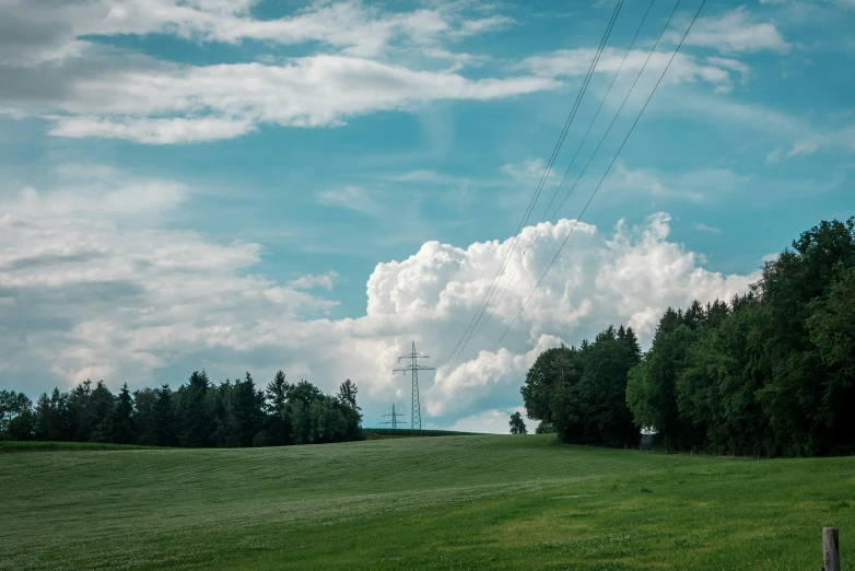 clouds are seen above a green field