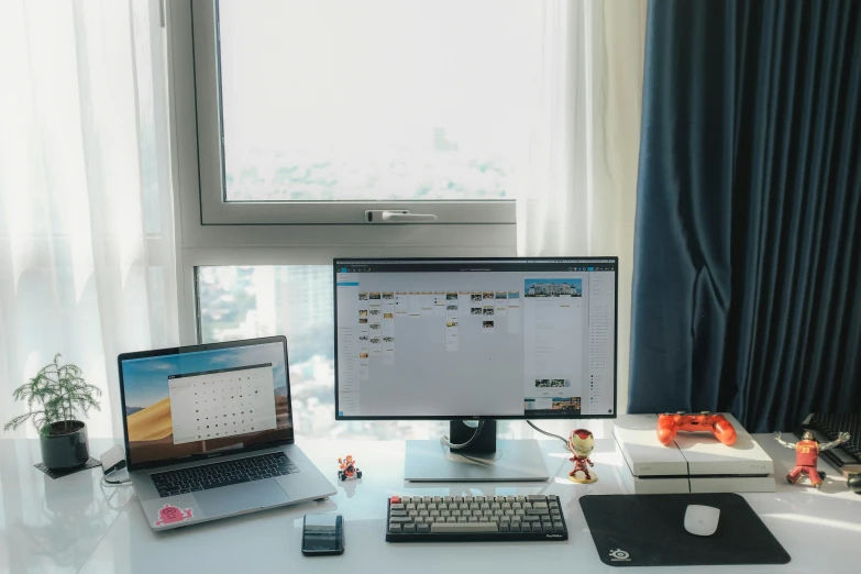 an office desk has computers and phone on it