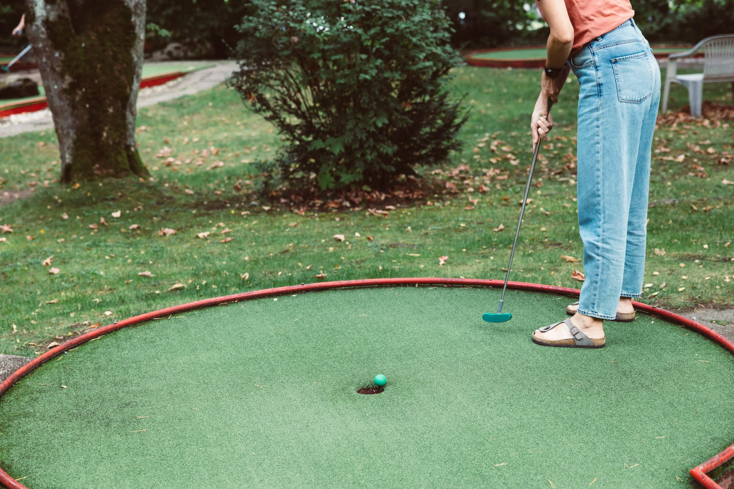 a woman putting mini golf balls in an interactive hole