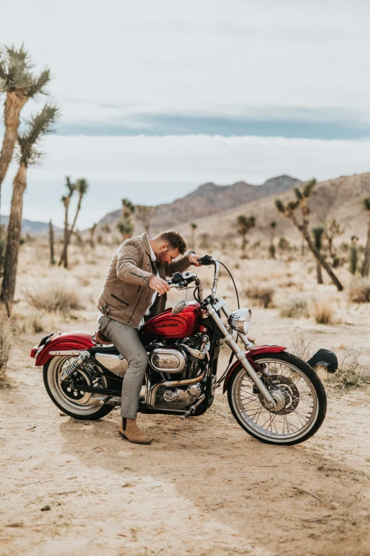 a man on a motorcycle looking down at his cell phone