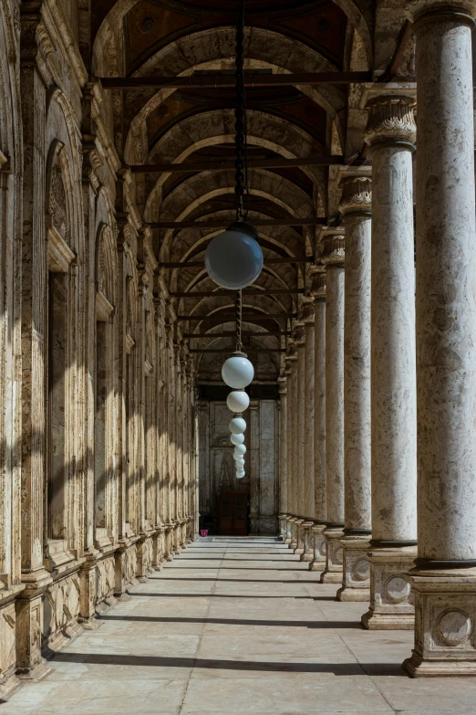 an empty long hallway with columns and arches