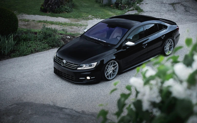 the front view of a black car parked in a driveway