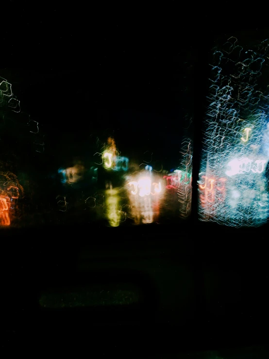 blurry city lights and buildings from behind a windshield