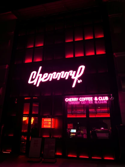 the exterior of a dark coffee shop with neon lettering