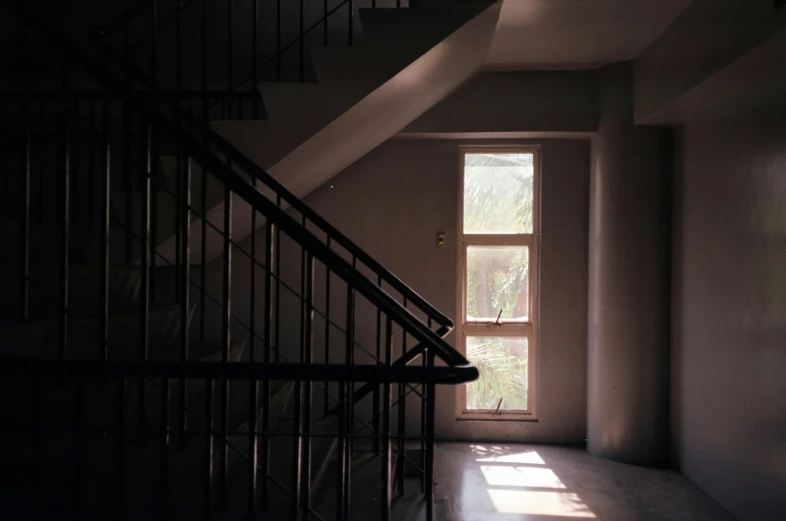 the inside of a house with stairs, windows and railing