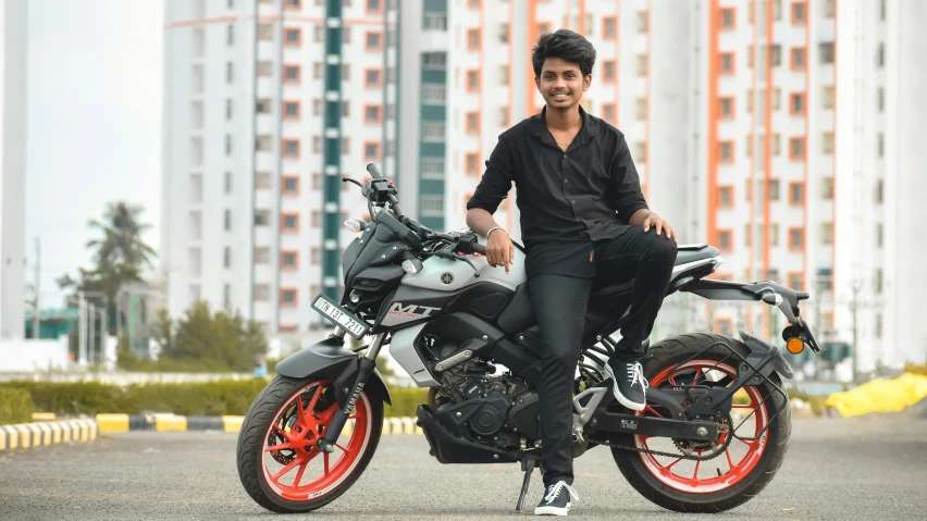 the man is sitting on his motorcycle posing for the camera