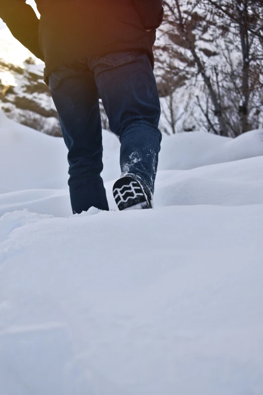 person standing in the snow with their foot up