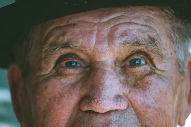 an old man wearing a top hat and green eyes