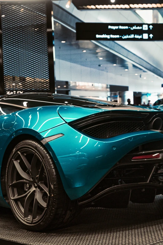 a blue, futuristic sports car sits on display