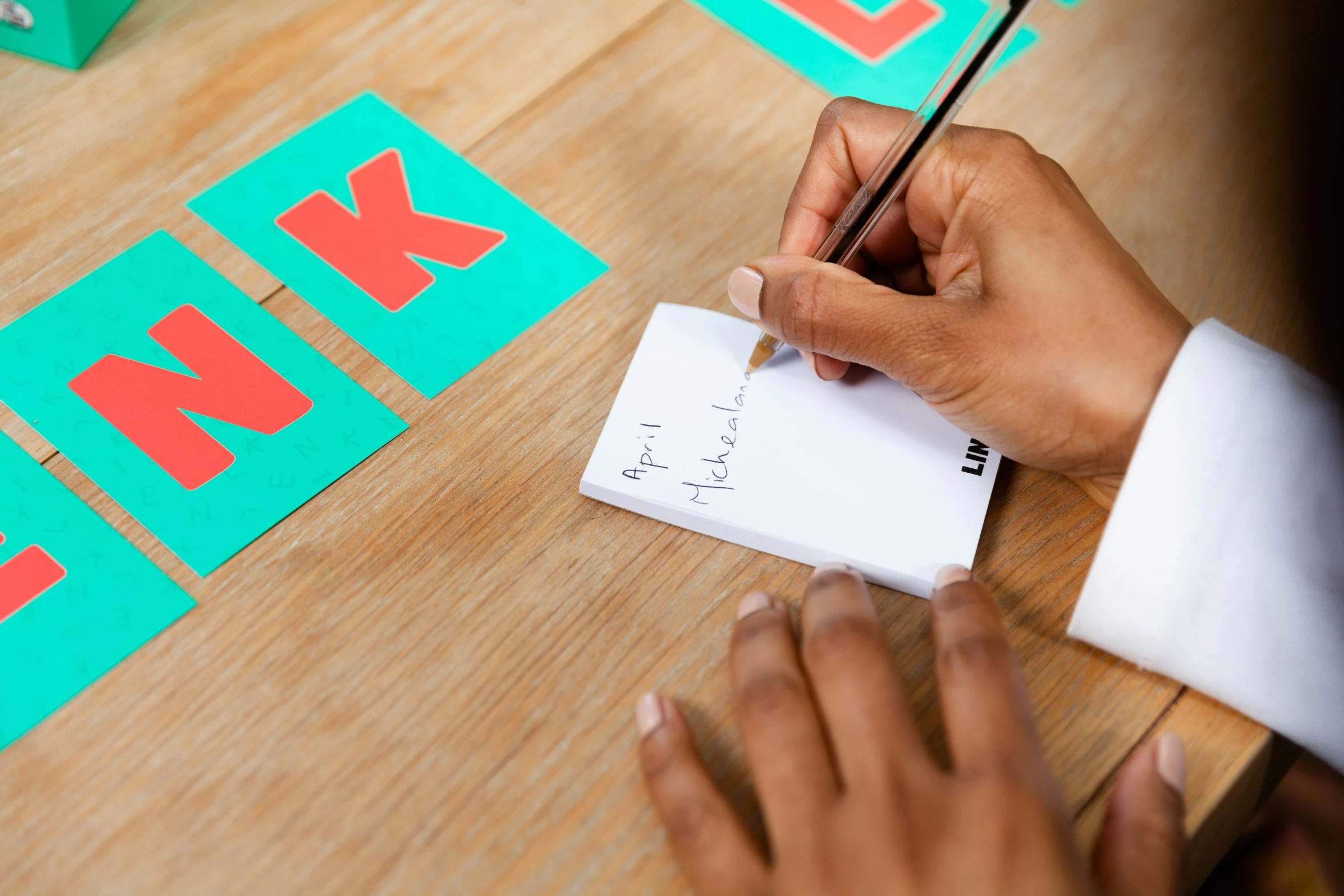 someone holding their pencil writing on top of a piece of paper