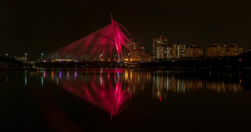 a large bridge spanning across a lake at night