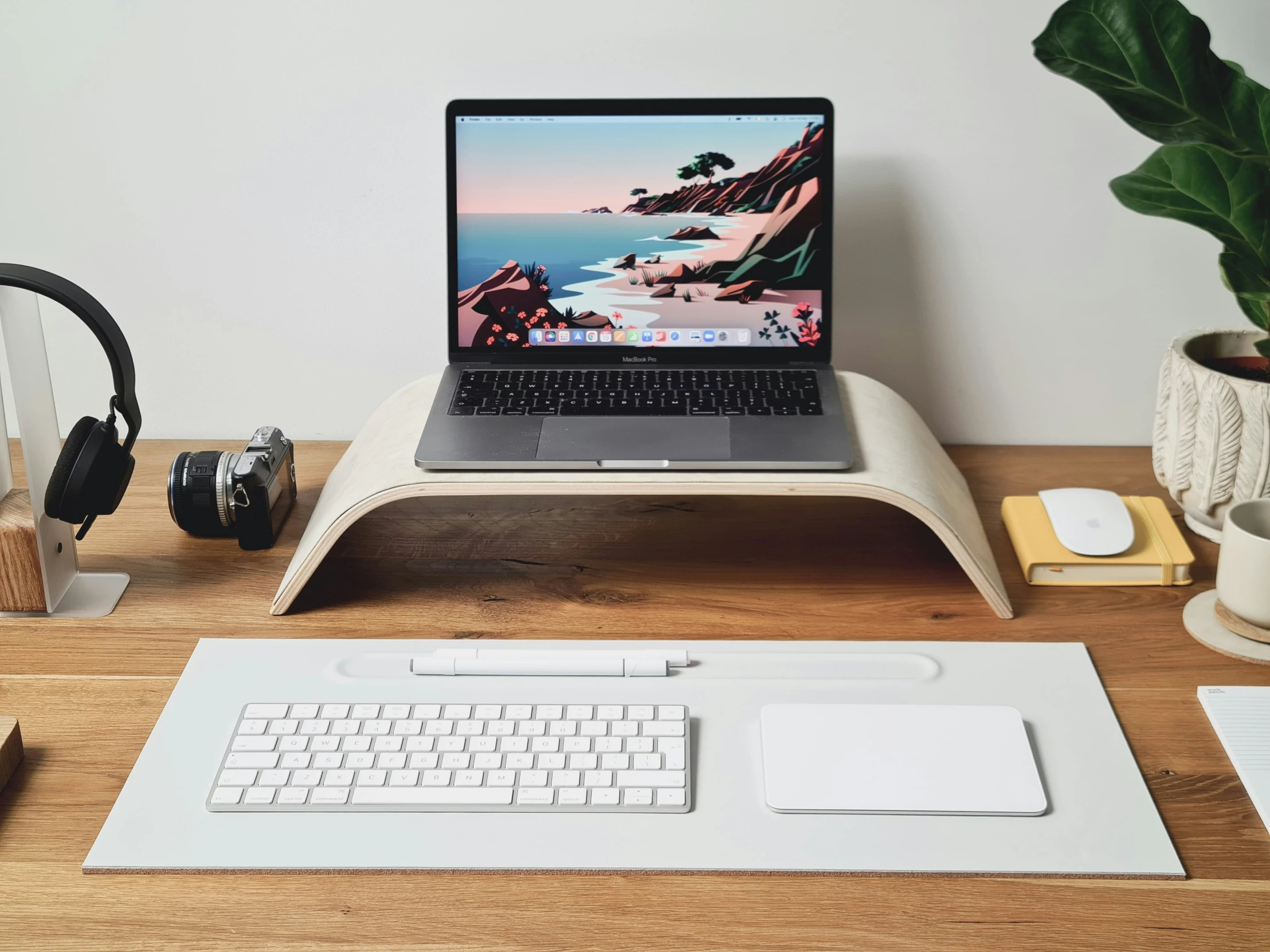 an apple laptop sitting on top of a white stand